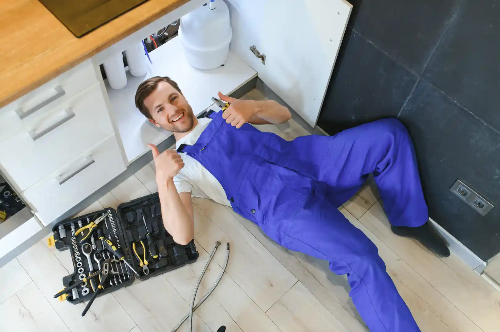 Licensed plumber in San Diego CA repairing plumbing fixtures indoors