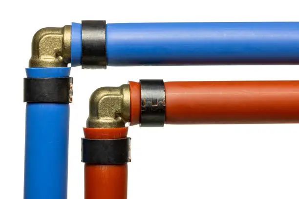 Blue and red PEX pipes connected with brass elbow fittings for home repiping.