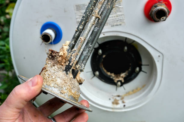 Corroded water heater heating element covered in heavy mineral sediment buildup from hard San Diego water.