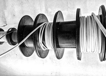 Coiled copper piping spooled on large reels for home plumbing installation.